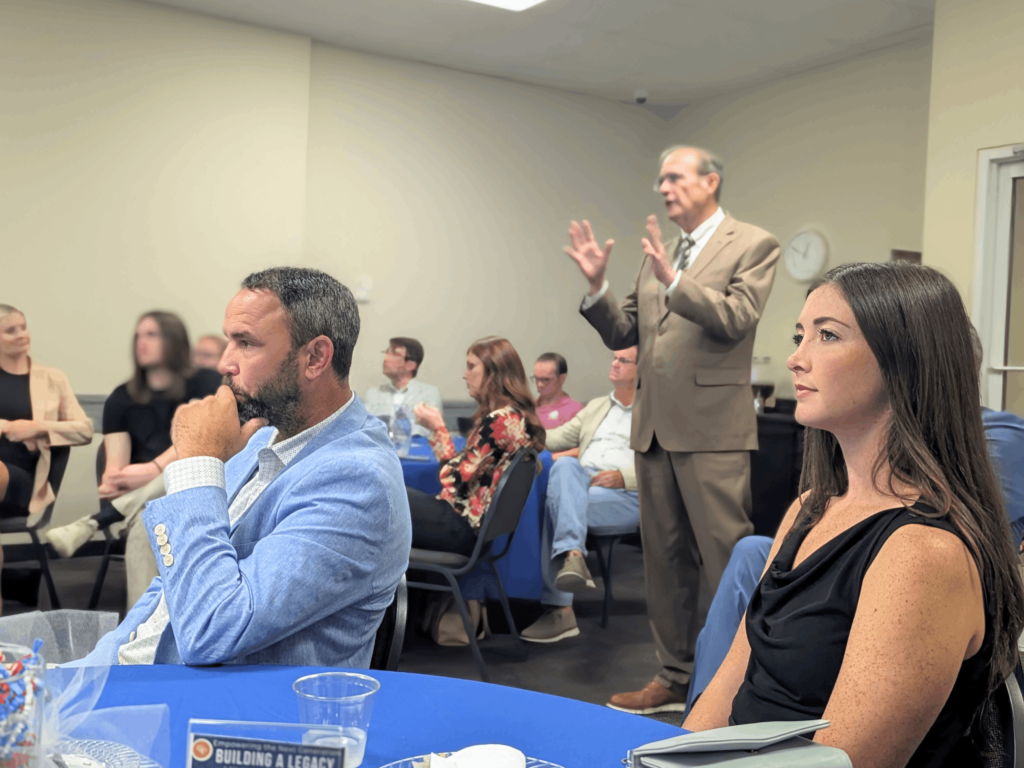 Arianna Ryker looks at a slide show presentation hosted by Mississippi's Lt. Governor Delbert Hosemann talks to Young Professionals about what he does at Lt. Governor and what Mississippi looks like for 2025 at the Gulf Coast Young Professions Luncheon.