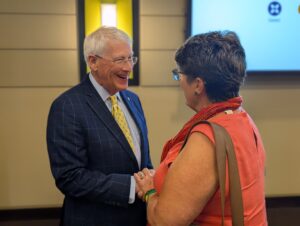 PXL_20250805_175709924.PORTRAIT Senator Roger Wicker smiles and shakes hands with a constituent during a one-on-one conversation following his remarks at the 2025 Legislative Luncheon in Biloxi. The informal setting allowed attendees to directly engage with the senator about local and national issues.