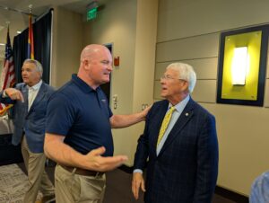 PXL_20250805_180025899 Michael McGill speaks with U.S. Senator Roger Wicker about FEMA funding for Long Beach, Mississippi, during the Gulfport Chamber of Commerce’s 2025 Legislative Luncheon. Both men appear engaged in conversation, surrounded by other attendees inside the event venue.