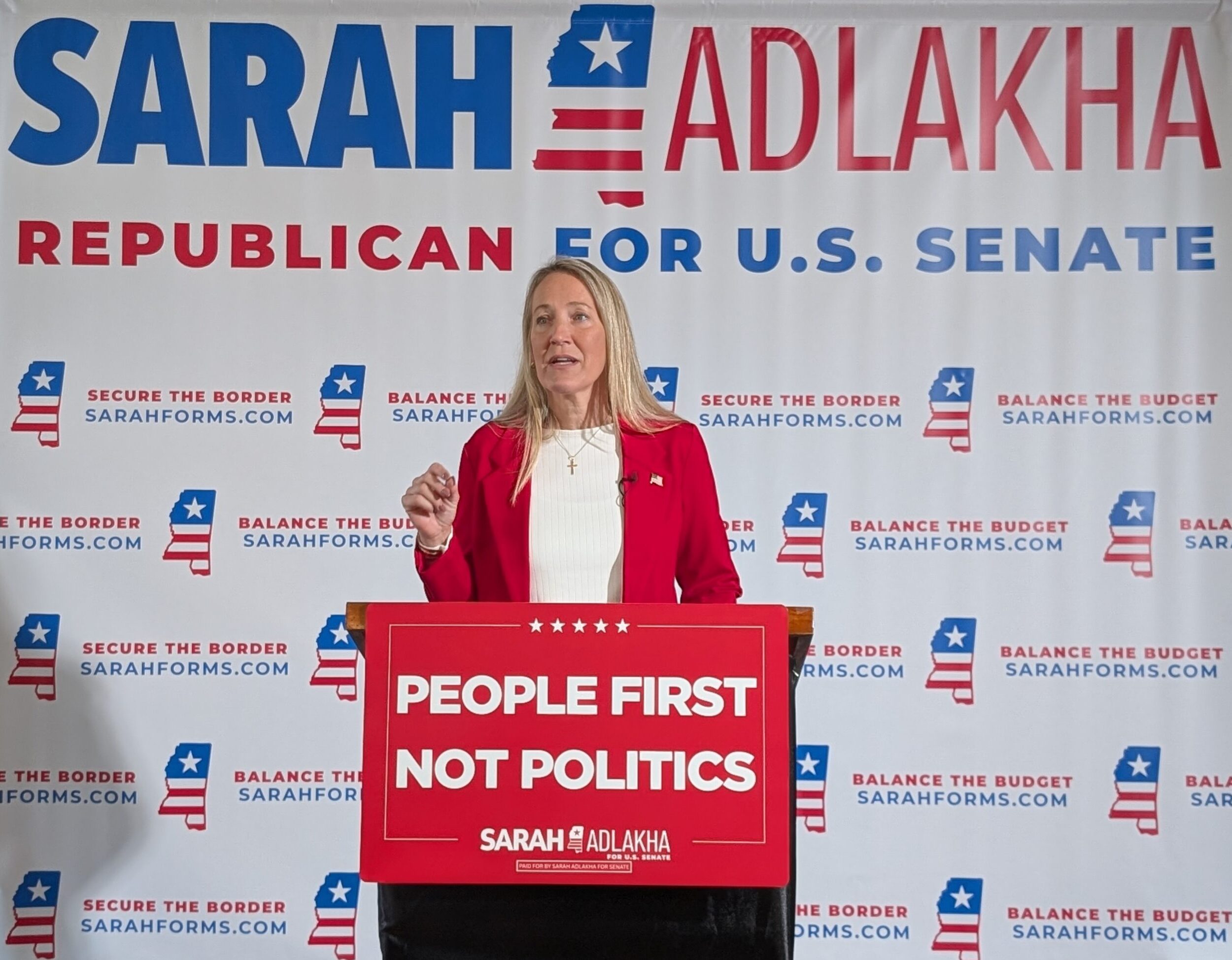 Sarah Adlakha stands at a podium to annocunce that she is running for Mississippi United States Senate